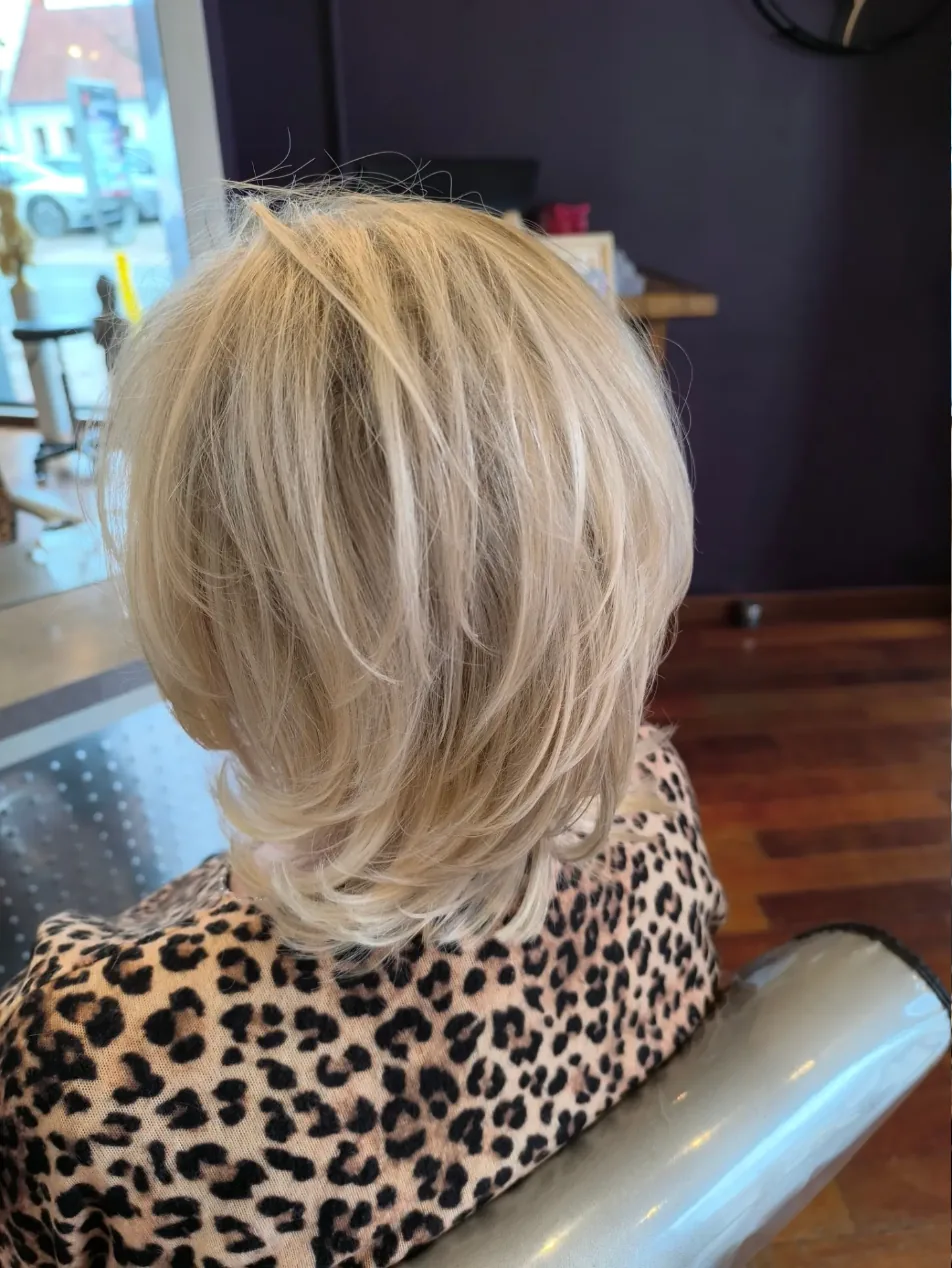 Coupe dégradée mi-longue en blond clair, réalisée chez Sohazen à Bray-Dunes